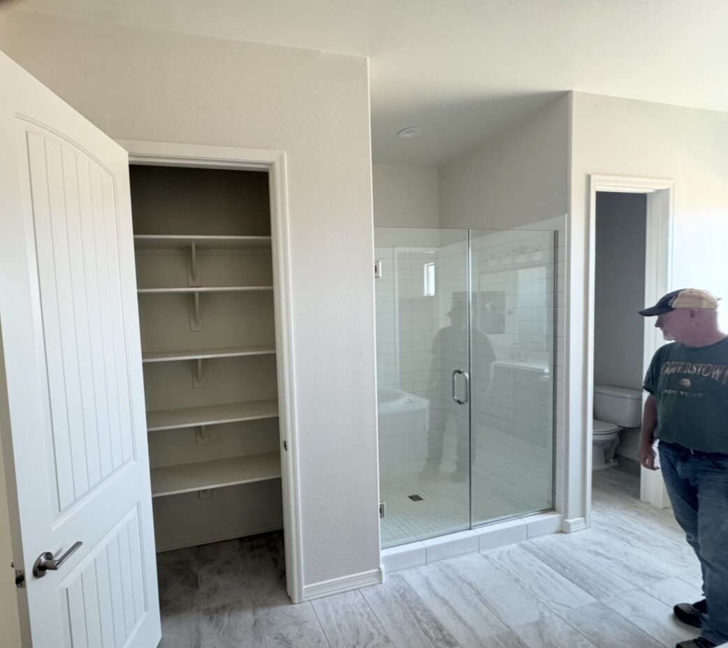Builder-grade master bathroom with small white tile shower before JBS remodel